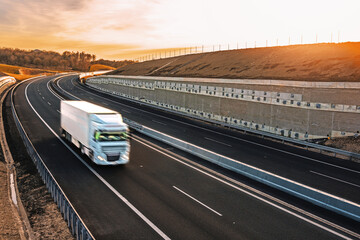 Fast moving blurry truck on the highway at sunset