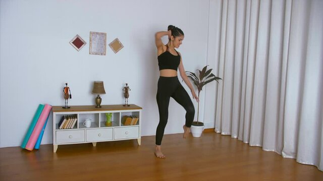 Slow-motion shot of a young sportswoman happily doing a Zumba dance workout. Long shot of an energetic female trainer demonstrating Zumba exercises in her fitness studio - healthy lifestyle concept