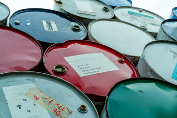 Old chemical barrels stack. Red, green, and blue chemical drum. Steel tank of flammable liquid....