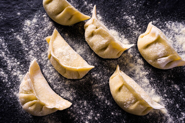 preparing Japanese ravioli close up, over dark stone table. Asian cuisine