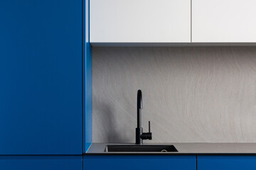 Elegant black sink and tap in modern kitchen with blue cupboards