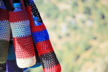 A colorful, hand-made water bottle bag hangs on Mount Tround, India.