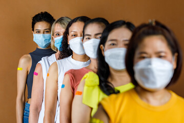 Diversity group of female from multinational ethnic patients wears face mask stand in line by...