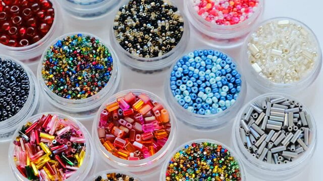 beads and bugles close-up . Handicraft and hobby concept. set of beads. Colored beads in round boxes set.