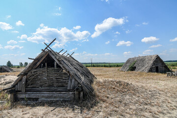 Old rustic wooden Slavian hut with roof made of straw in Svalovychi village in Ukraine.