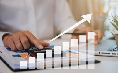 Businessman working using a calculator to calculate the tax of static in office. Finance accounting...
