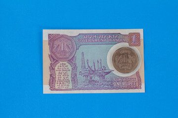 Indian Old vintage coin and paper note of One Rupee. old coin isolated on one rupee paper note background. Valid currencies. Old Indian Currency old Coin and bank note. 