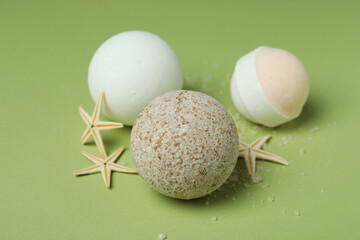 Bath balls and starfishes on green background, close up