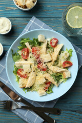 Concept of tasty eating with Caesar salad on wooden table