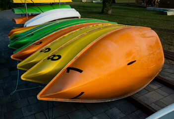 Many colorful plastic boats for rent on land