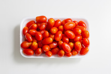 red cherry tomatoes in a plastic container, top view, cherry tomatoes in a bowl