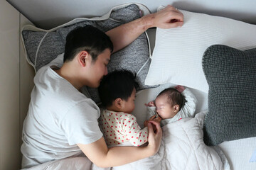 침대에서 자고있는 아버지와 아들들