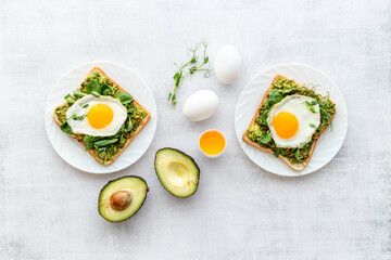Toasts with eggs and avocado cream and spinach. Top view