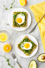 Breakfast with avocado toasts and fried eggs, top view