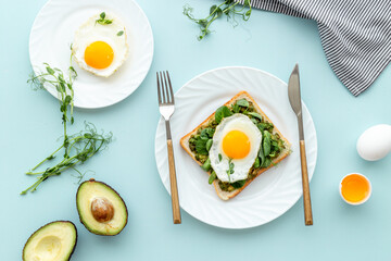 Toasts with eggs and avocado cream and spinach. Top view