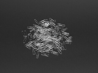 Paper clips are scattered on a black background