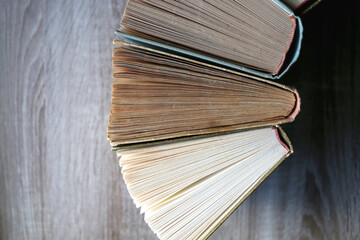 Vintage hardcover books on a wooden table. Top view.