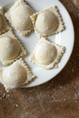 ravioli raw dough filling square dumplings on the table, healthy meal copy space food background rustic. top view