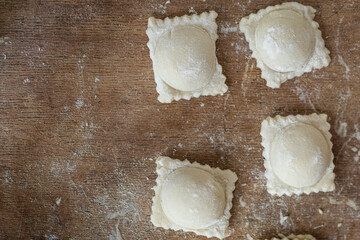 ravioli raw dough filling square dumplings on the table, healthy meal copy space food background rustic. top view