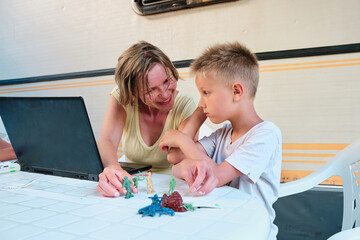 a mother working in her caravan tries to animate her kid