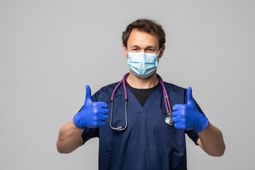 Fototapeta na wymiar Doctor male surgeon with thumbs up over a white background