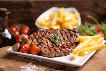 Sliced grilled medium rare beef steak served with fries