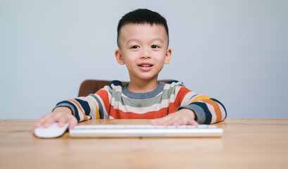 smart kids, Cute Asian Boy using a mouse and computer keyboard, homeschooling, online study, home quarantine, online learning, corona virus or education technology concept