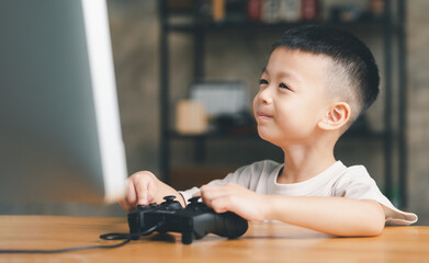 Asian boy kid child Playing with videogames joystick.