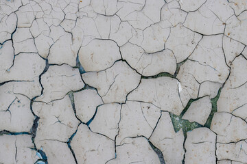 Peeling paint on the wall. Old concrete wall with cracked flaking paint. Weathered rough painted...