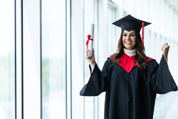 Female graduate celebrating victory sign on Uni