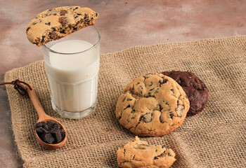 American Chocolate Chips Cookies, Soft Cookies  Served with A Glass of Fresh Milk  on Brown background. Copy Space for Text or Recipe