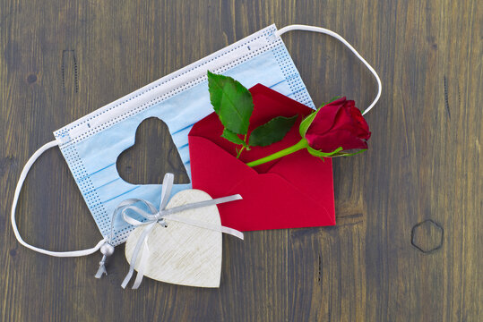 Medical mask heart shape and red rose in envelope