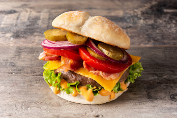 Beef burger with cheese and bacon on wooden table