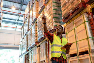 Naklejka na ściany i meble Black male worker teamwork in factory warehouse. Black man manager doing inspection using tablet at factory indoor of building in background shelves with goods Logistic of industry transport