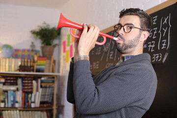 Teacher playing trumpet in classroom