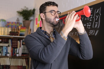 Teacher playing trumpet in classroom
