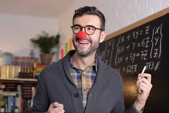 Humorous teacher wearing clown nose in classroom