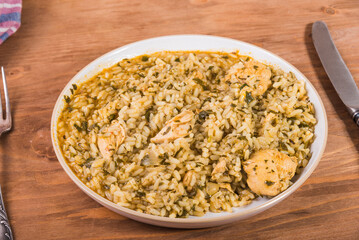 Rice porridge with chicken - risotto with chicken breast in a plate on the table