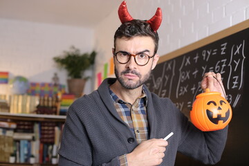 Teacher holding pumpkin during Halloween celebration