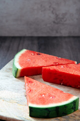 three triangular pieces of watermelon on a motherboard and rustic background