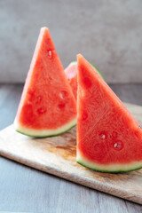 three triangular pieces of watermelon on a motherboard and rustic background