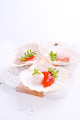 Preparing healthy gourmet food, seared scallops with caviar on on a beautiful dish in shellfish shells. A traditional dish of france and italy sea food. Seafood on white background