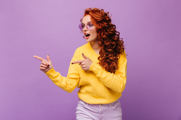 Girl in yellow outfit and glasses points her finger at place for text