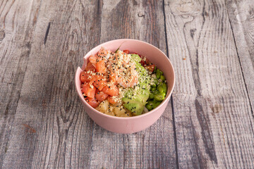 Hawaiian salmon poke bowl with avocado, edamame, cooked shrimp, cherry tomatoes, pineapple and rice base
