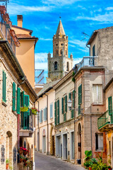 Fototapeta na wymiar Narrow street in the town of Atri with a view of the cathedral bell tower, Italy