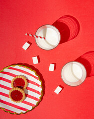 Colorful layout made of milk glasses and tasty cookies with sugar cubes. Creative breakfast sunlit...