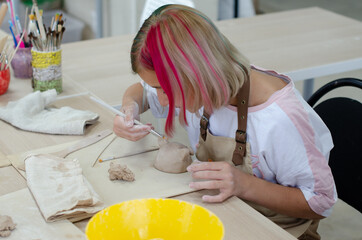 a girl makes clay products in a pottery workshop. Teamwork, learning
