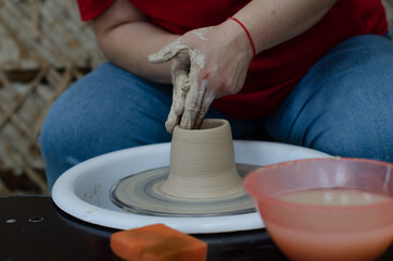 Fototapeta na wymiar A pottery master makes a jug from clay. Hands close up