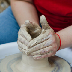 A pottery master makes a jug from clay. Hands close up