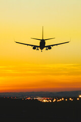 Fototapeta na wymiar Airplane landing on the runway during sunset and dusk